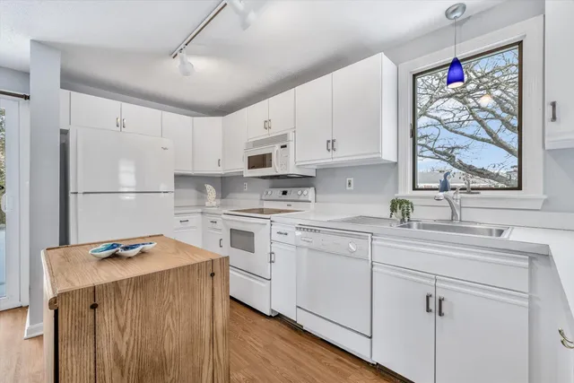 a kitchen with white cabinets and white appliances