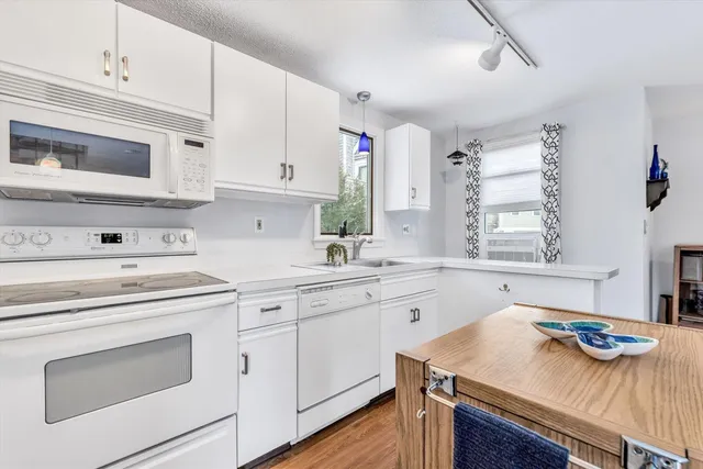 a kitchen with cabinets appliances a sink and a window