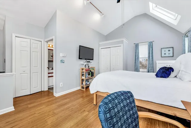 a bedroom with a bed and a flat tv screen on dresser