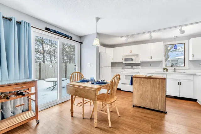 a kitchen with granite countertop wooden floors and white cabinets
