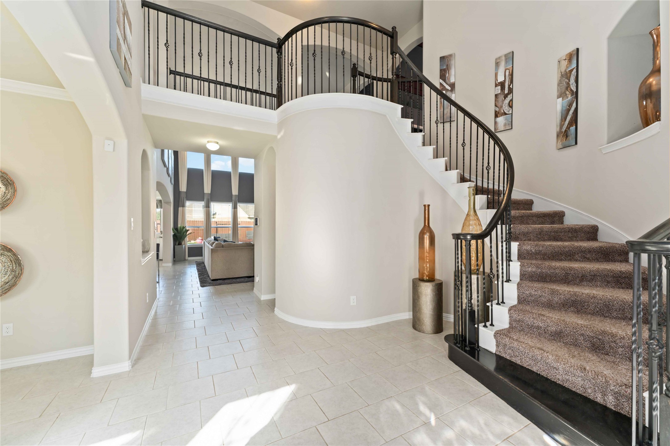 Step inside to soaring ceilings, graceful architectural details, and an open, light-filled entry that immediately feels welcoming. The curved staircase, arched openings, and natural light set the tone for the home’s spacious and thoughtfully designed layout.