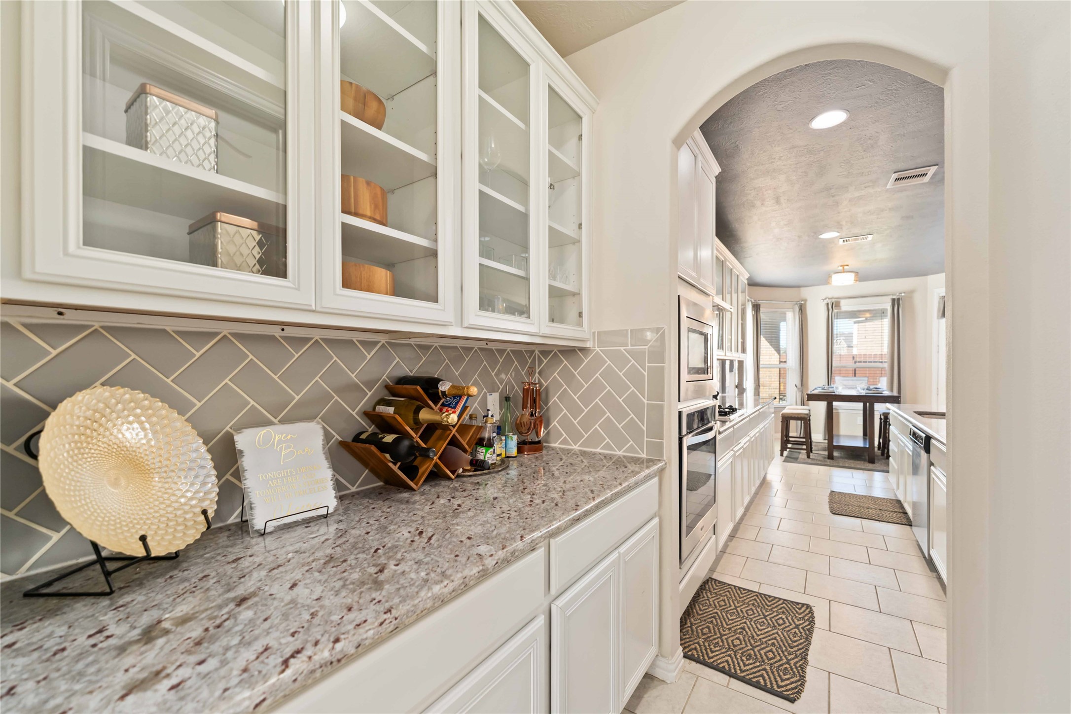 7403 Dry Stone Lane Rosenberg, TX 77469 - Photo 8 of 19 This extra counter space just off the kitchen is ideal for a coffee station or serving area, offering additional storage and prep space exactly where you need it. The herringbone tile backsplash perfectly polishes the space.