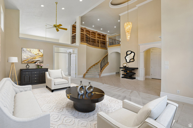 220 East Ridge Road Orem, UT 84057 - Photo 4 of 52 Two-story foyer with a grand curved staircase, built-in library shelving, tray ceiling, and an elegant chandelier