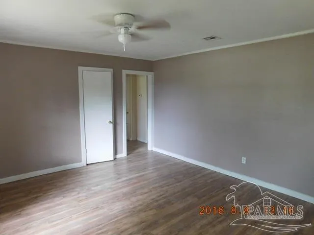 a view of an empty room with wooden floor