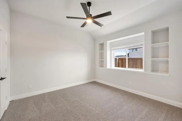 an empty room with a window and a fan