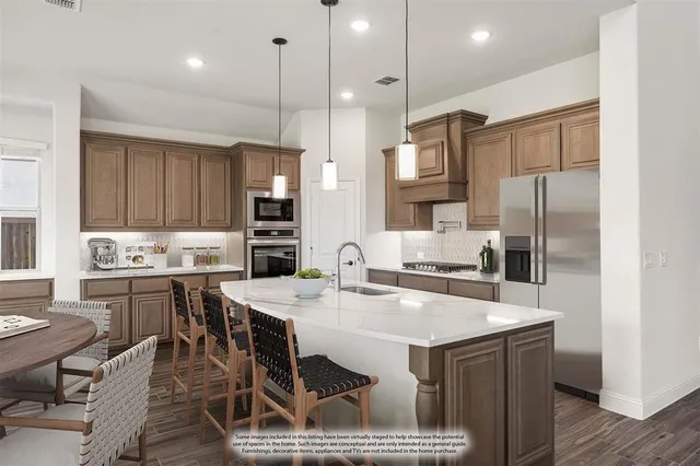 a kitchen with a refrigerator a sink a stove a dining table and chairs