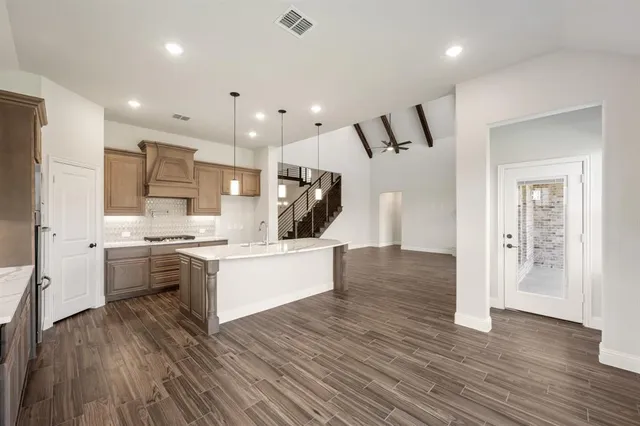 a kitchen with a sink and wooden floor
