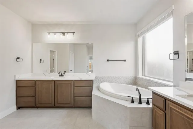 a spacious bathroom with a tub shower and sink