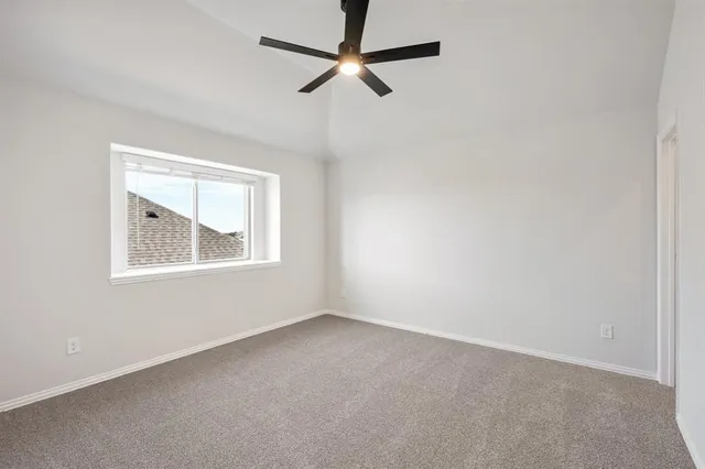 an empty room with windows and ceiling fan