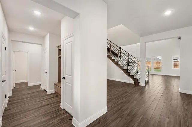 a view of a hallway with wooden floor and stairs