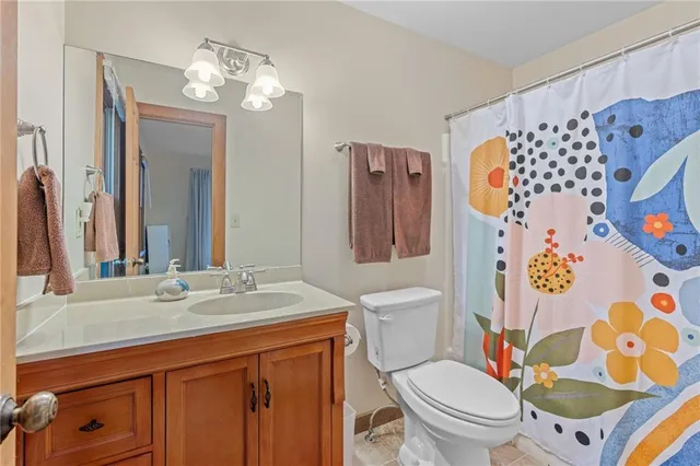 a bathroom with a granite countertop toilet sink and mirror