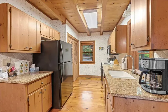 a kitchen with stainless steel appliances granite countertop a sink refrigerator and cabinets