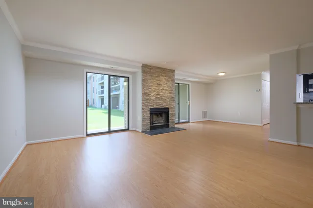 a view of an empty room with a fireplace and a window