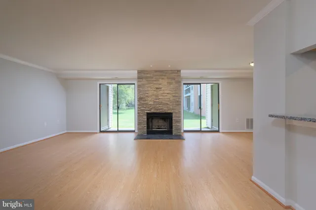 a view of an empty room with a fireplace and a window