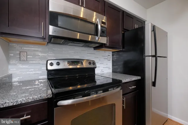 a kitchen with stainless steel appliances granite countertop a stove and a microwave