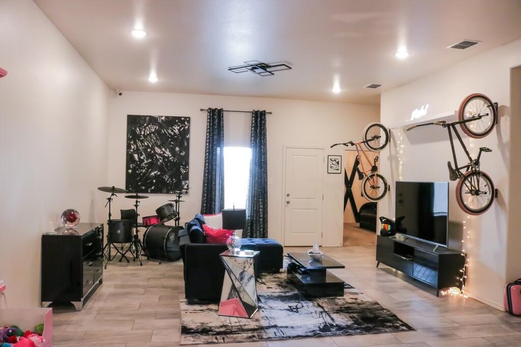 5532 Kemper Street Lubbock, TX 79416 - Photo 2 of 11 a living room with furniture a window and gym equipment
