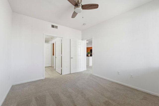 an empty room with windows and ceiling fan