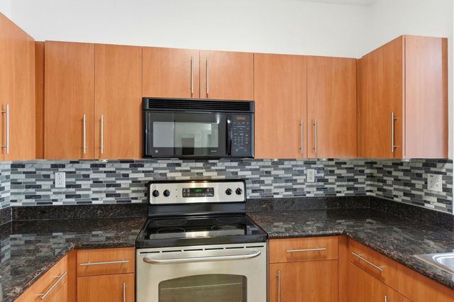 a kitchen with stainless steel appliances granite countertop a refrigerator oven a sink and a granite counter tops