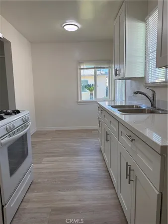 a kitchen with a sink stove and cabinets