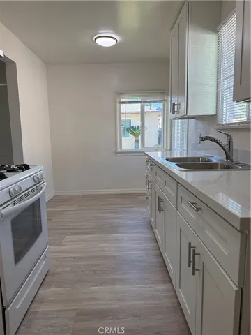 a kitchen with a sink stove and cabinets