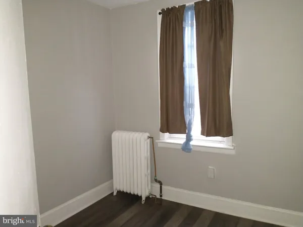 a view of a small space with wooden floor and a window