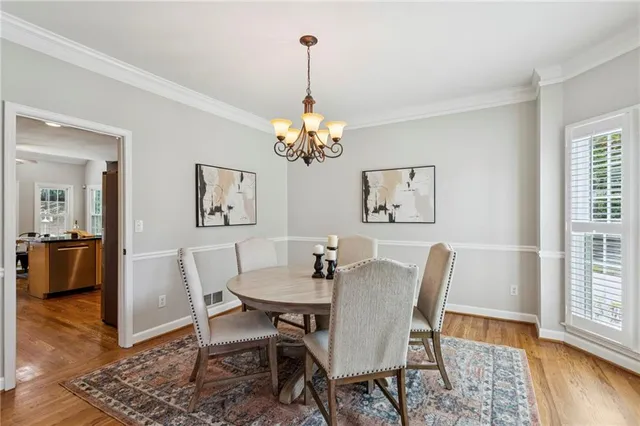 a dining room with furniture wooden floor a rug and a chandelier