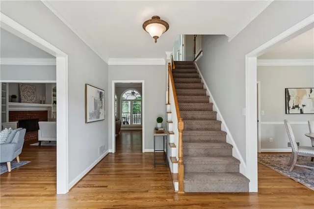 a view of a hallway with wooden floor and staircase