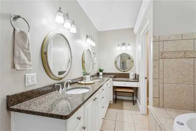 a bathroom with a granite countertop sink a mirror and a shower