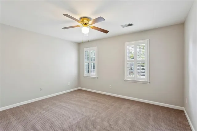 an empty room with a window and ceiling fan
