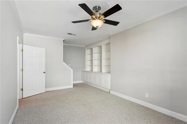 an empty room with ceiling fan and window