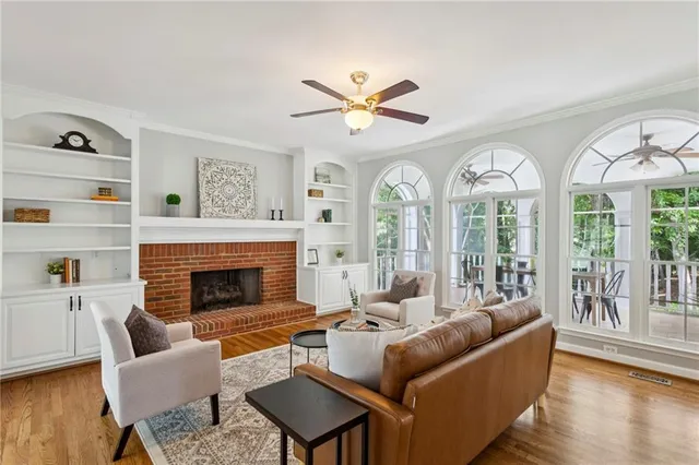 a living room with furniture fireplace and a large window