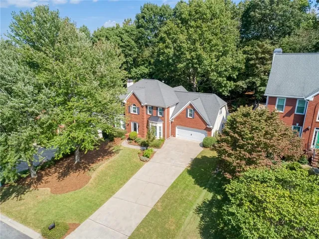 a view of a house with a yard and potted plants