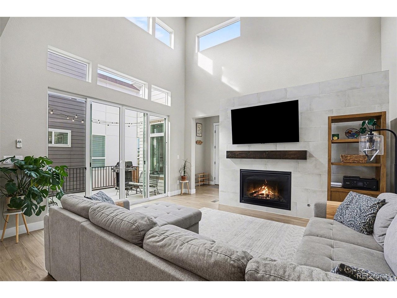 a living room with furniture a flat screen tv and a fireplace