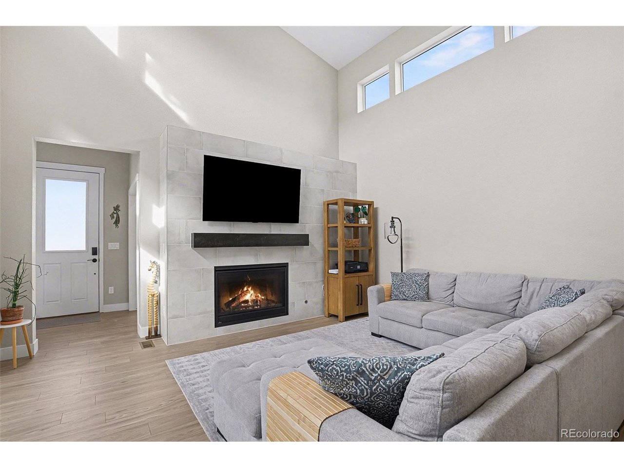 9958 East 63rd Place, Unit 2 Denver, CO 80238 - Photo 7 of 35 a living room with furniture a flat screen tv and a fireplace