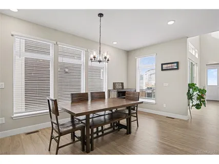 a dining room with furniture potted plants and wooden floor