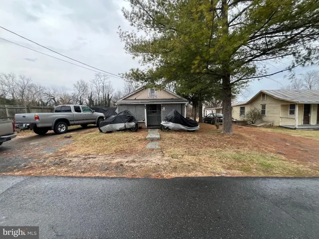 a view of a house with a cars park side of a road