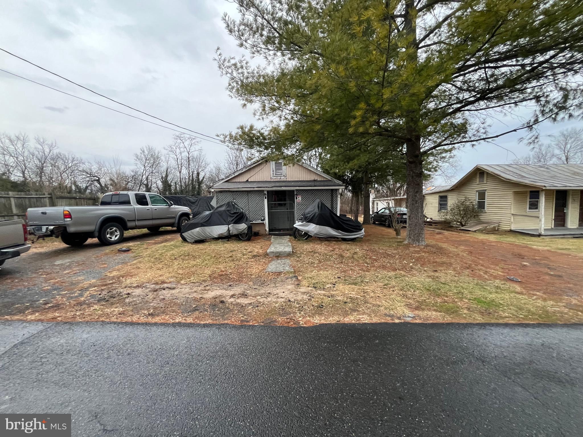 a view of a house with a cars park side of a road