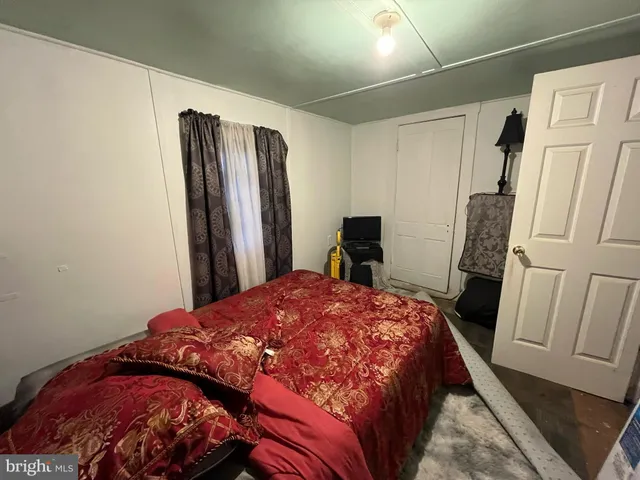 a bedroom with a bed and a refrigerator