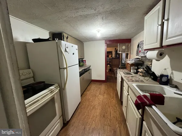 a kitchen with a refrigerator a stove and wooden floor