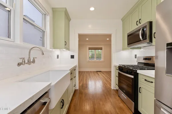 a kitchen with a sink and wooden floor