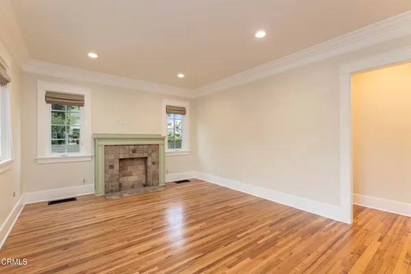 a view of empty room with wooden floor and fireplace