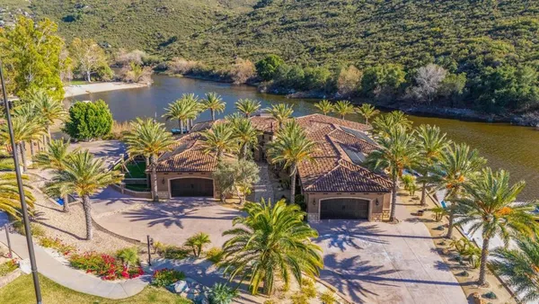 an aerial view of a house with a garden and lake view