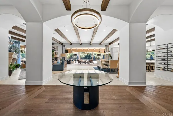 a view of a dining room with furniture a chandelier and wooden floor