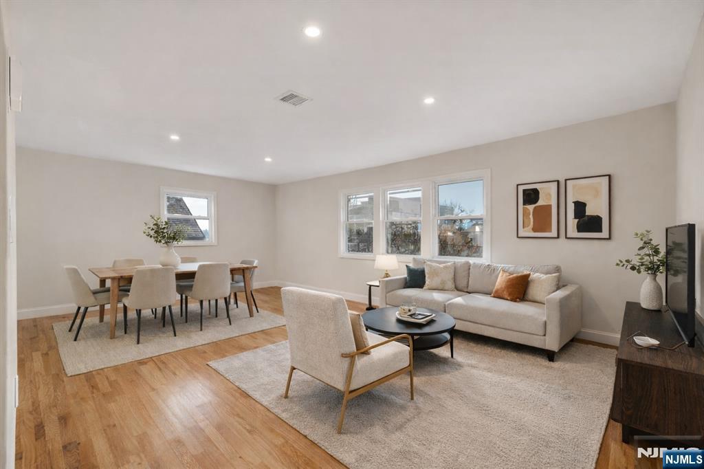 13 Casta Lane, Unit 2 Edgewater, NJ 07020 - Photo 1 of 23 a living room with furniture dining table and a large window