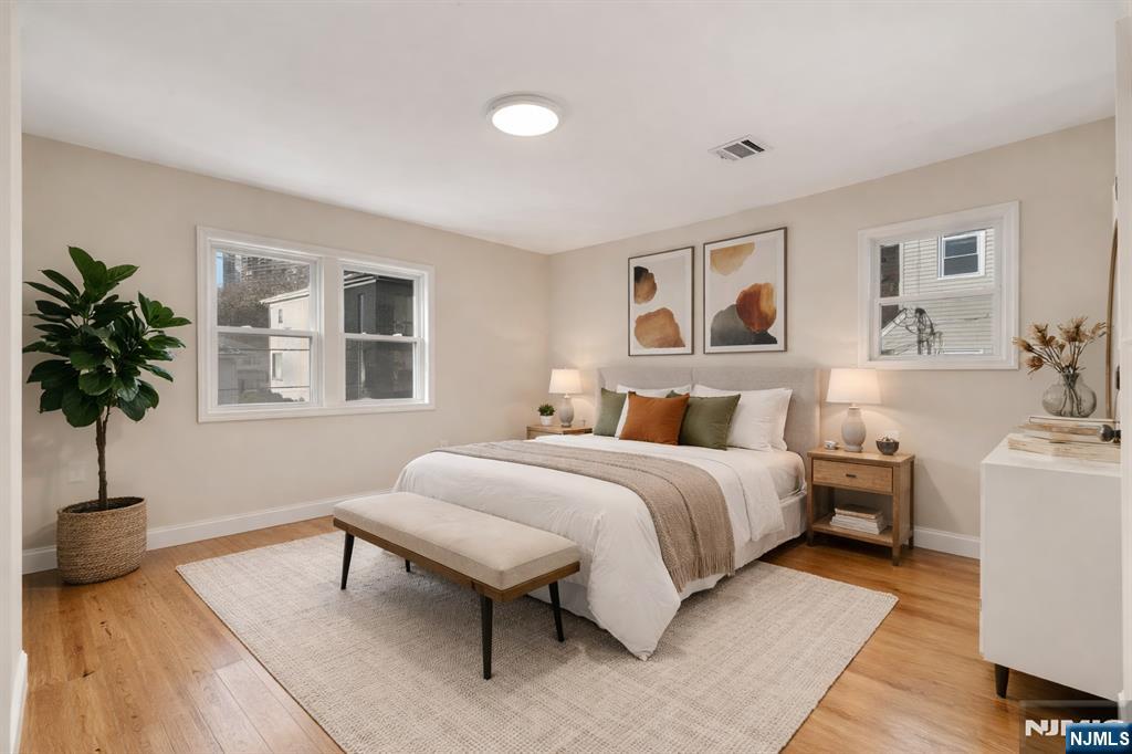 13 Casta Lane, Unit 2 Edgewater, NJ 07020 - Photo 2 of 23 a spacious bedroom with a bed and a potted plant