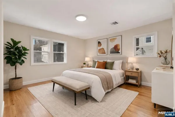 a spacious bedroom with a bed and a potted plant