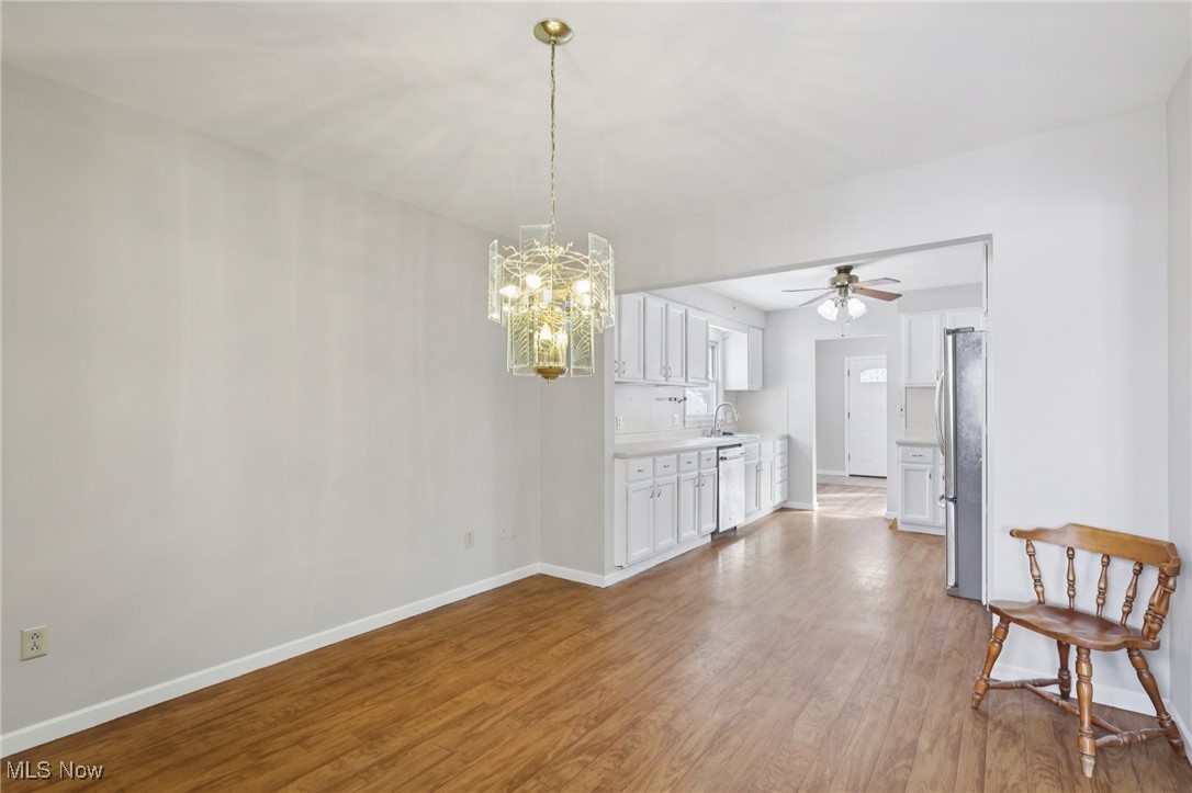 611 Wilson Street Struthers, OH 44471 - Photo 11 of 44 Unfurnished dining area with light wood-type flooring, a chandelier, and ceiling fan