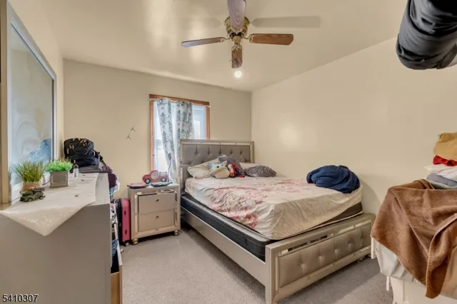 a bedroom with a bed and ceiling fan