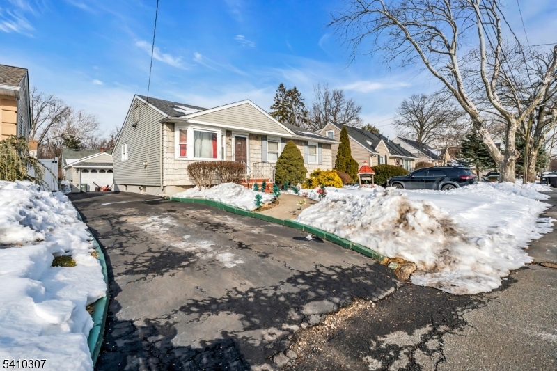 693 Hemlock Street Rahway, NJ 07065 - Photo 2 of 29 a view of a white house with a yard covered in snow