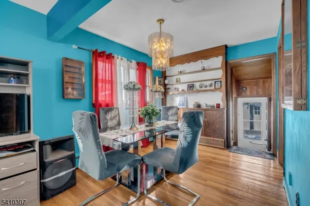 a dining room with furniture a chandelier and wooden floor